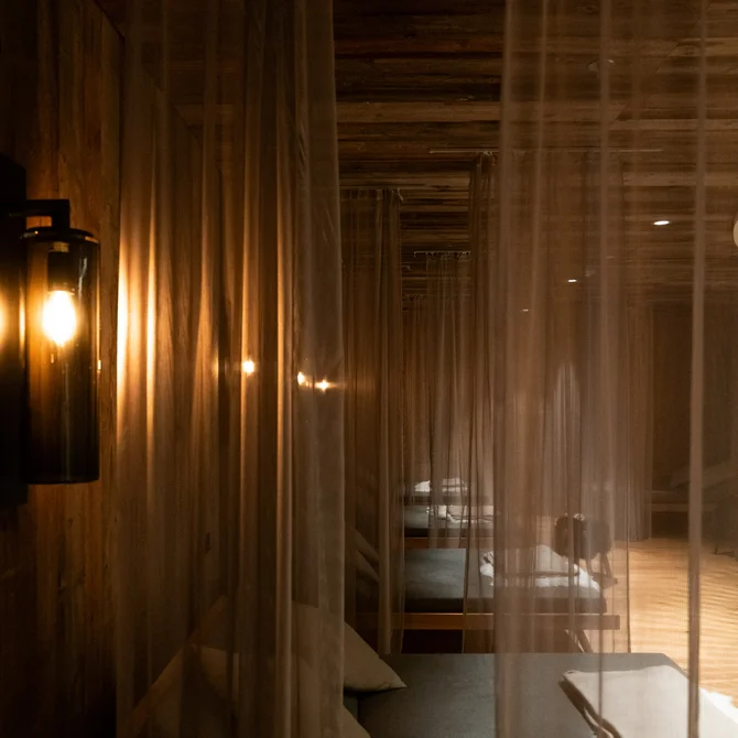 Dimly lit room with sheer curtains and lounge beds