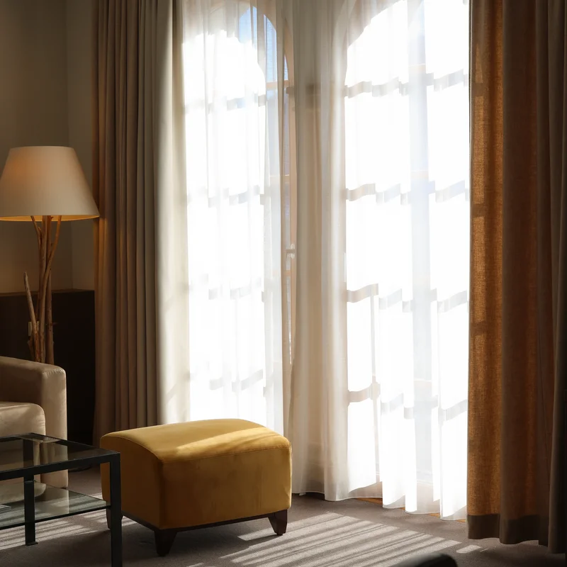 Helles Wohnzimmer mit gelbem Hocker und einem Bodenlampenständer