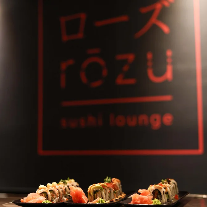 Drei Teller mit Sushi vor einem Rosu Sushi Lounge Schild