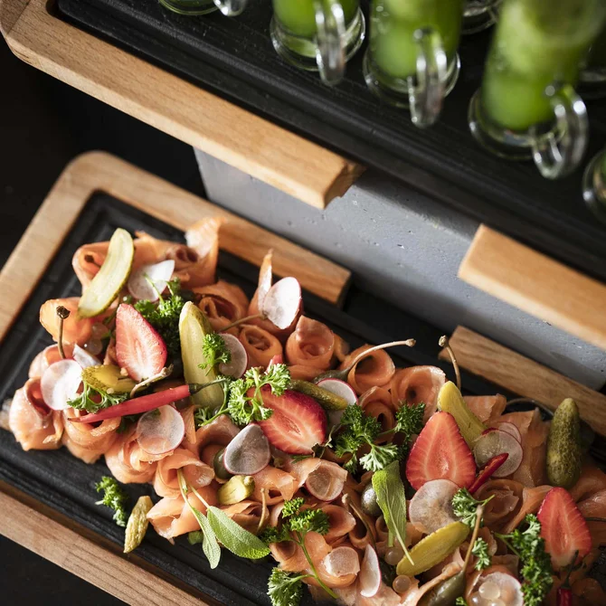 Lachslachs mit Gurke, Erdbeere, Kräutern und Gurken auf Holzplatte