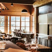 Gemütliches Restaurant mit Holzeinrichtung und gedeckten Tischen