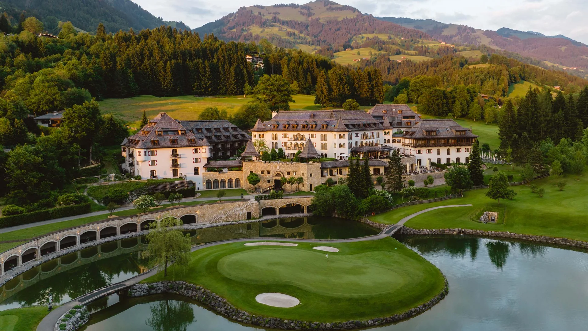 Luxushotel und Golfplatz mit Bergblick in einer grünen Landschaft