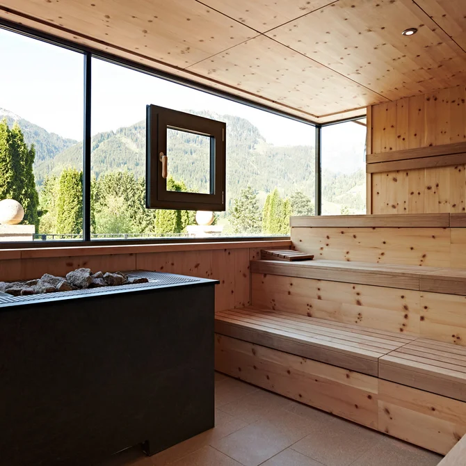 Wood-paneled sauna with panoramic window showing mountain view